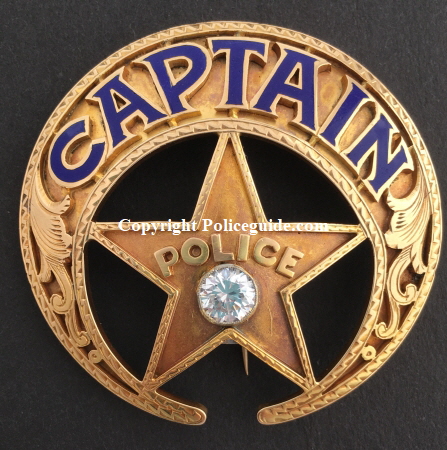 New Orleans Police Captain badge, 14k gold, adorned with a diamond, with hard fired blue enamel lettering and hand engraved gold inlay designs.