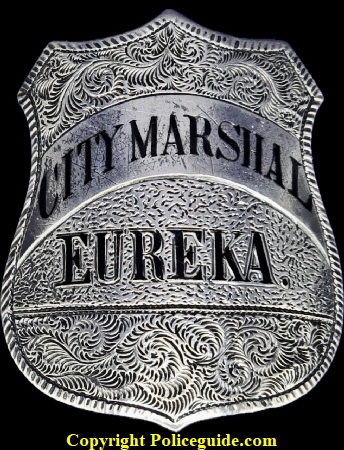 City Marshal Eureka shield, sterling silver, hand engraved, hard fired black enamel lettering.  The first City Marshal for Eureka was appointed in 1858.  On June 9, 1887 Ordinance 110 specifically designated the City Marshal as the ex-officio police chief.  In 1895 the title �City Marshal� was eliminated and the position of �Chief of Police� was created.