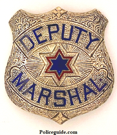 Deputy Marshal made in sterling, hand engraved with two colors of hard fired enamel.  Hallmarked J. C. Irvine