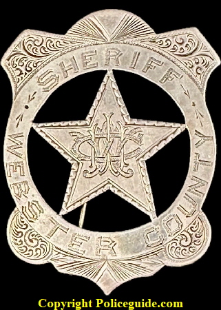 Sheriff Webster County IA shield, with monogram initials WWC in the center. Made of sterling silver. He was Sheriff 1894-1897. Sheriff Webster County IA shield, with monogram initials WWC in the center. Made of sterling silver. He was Sheriff 1894-1897.