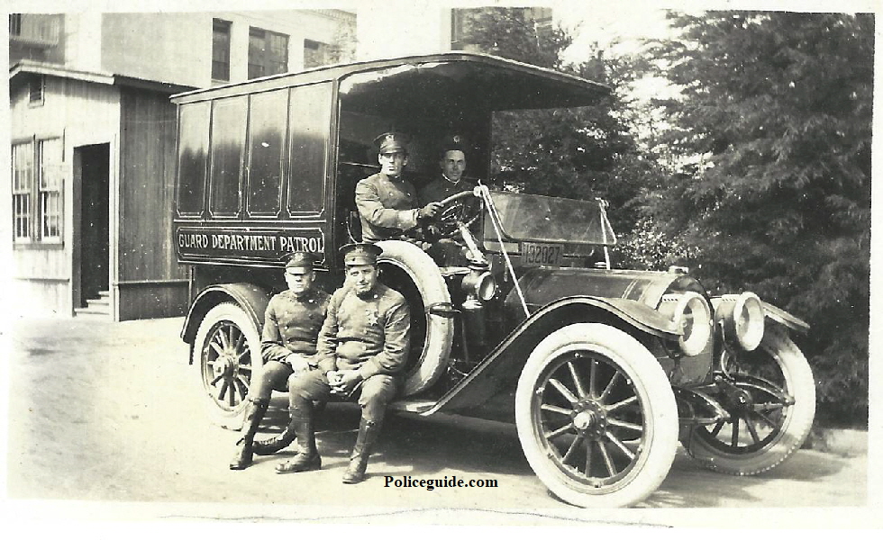 Bert Lundy behind the wheel of the “Guard Department Patrol” wagon with three other members.