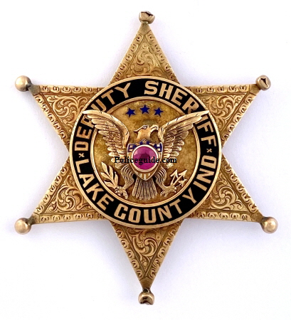 14k gold Lake County, IN Deputy Sheriff badge.  Hand engraved surmounted by an eagle with a red stone in the chest.  Lettering done in Black reverse enamel.