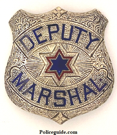 Deputy Marshal made in sterling, hand engraved with two colors of hard fired enamel.  Hallmarked J. C. Irvine