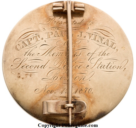 Back of Boston Police presentation badge showing inscription:  Presented to Capt. Paul J. Vinal by the members of the Second Police Station Boston Nov. 15, 1870.   Badge is solid gold.