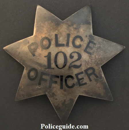 Officer J. W. Slagle wearing badge No. 102.  Badge is sterling and dated 10-14-19.