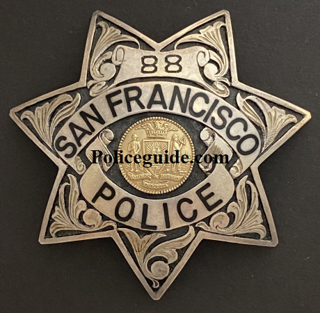 S.F.P.D. Prototype Badges.  Back in the 1970’s it was felt by the department that they should explore going to a more unique police badge.  Irvine & Jachens was tasked with coming up with new designs for consideration.  These three prototype’s were considered.  Badge number 88 was the badge number assigned to officer Russ Dickey.   Russ was issued the badge to wear on duty and seek opinions and feedback from fellow officers and the public.  Both badges 88 and 123 are sterling silver with hand engraved leafing highlighted by recessed black enamel.  Badge 0000 was a departure from the 7 point star worn for more than 100 years.  The badge featured reverse blue enameled panels and borders and a sterling silver city seal.  Tradition won out and it was decided no change would be made.  To this day badge 88 worn by Russ Dickey is the only department authorized prototype badge to be worn.