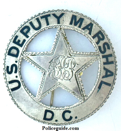 U. S. Deputy Marshal D. C. (District of Columbia, Washington D.C.) with the initials “J. B. P.” monogramed in the center.  This sterling silver badge was worn by J. B. Peyton and his name is inscribed on the back.